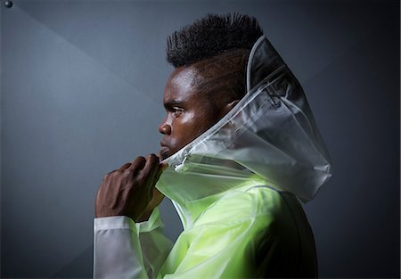 raincoat hood - Profile of young man with mohawk, putting on waterproof jacket Stock Photo - Premium Royalty-Free, Code: 614-08726702