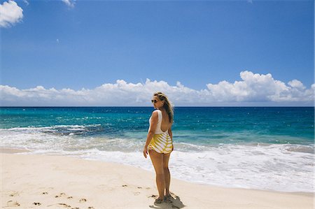 simsearch:614-08726746,k - Pregnant mid adult woman wearing swimming costume looking back from Makua beach, Hawaii, USA Foto de stock - Royalty Free Premium, Número: 614-08726748