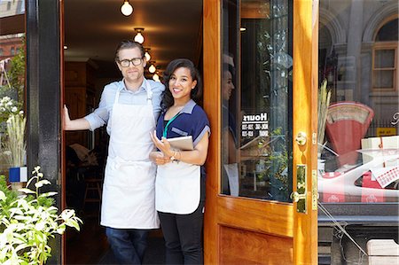 panificio - Portrait of male and female workers in bakery, standing in doorway Fotografie stock - Premium Royalty-Free, Codice: 614-08720556