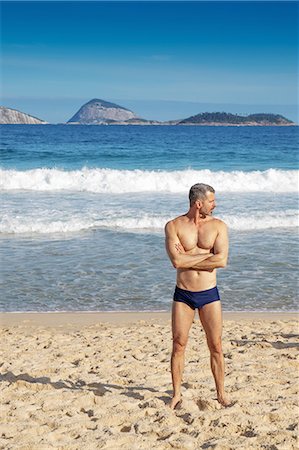 Mature man standing on beach, Ipanema, Cagarras islands, Rio de Janeiro, Brazil Stock Photo - Premium Royalty-Free, Code: 614-08720564