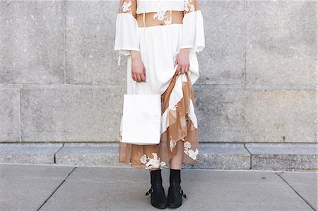 debajo de la cintura - Low section of woman holding shopping bag Foto de stock - Sin royalties Premium, Código: 614-08720644