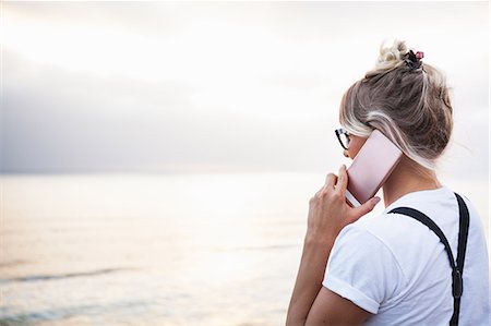 Woman by ocean making telephone call on smartphone, Encinitas, California, USA Stock Photo - Premium Royalty-Free, Code: 614-08720650