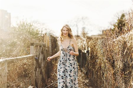 Young woman walking along rural farm pathway, smiling Photographie de stock - Premium Libres de Droits, Code: 614-08720858