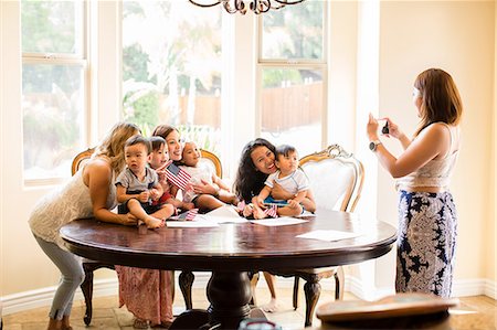 Woman taking photograph of mothers and babies at dining table Stock Photo - Premium Royalty-Free, Code: 614-08720967