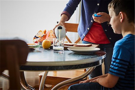 Mother pouring glass of milk for son Photographie de stock - Premium Libres de Droits, Code: 614-08721029