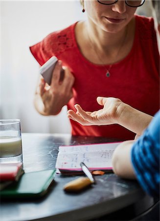 Mother and son at dining table having discussion Stock Photo - Premium Royalty-Free, Code: 614-08721036