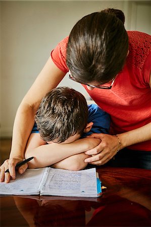 sad boy for mom - Mother comforting upset son doing homework Stock Photo - Premium Royalty-Free, Code: 614-08721045