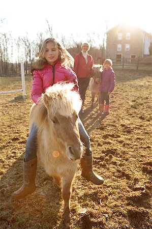 simsearch:614-08880760,k - Young girl riding pony, mother and sister watching from behind Foto de stock - Royalty Free Premium, Número: 614-08768446