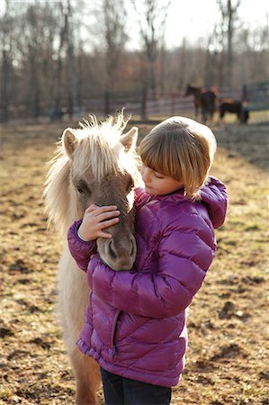 simsearch:614-08880760,k - Young girl outdoors, hugging pony Foto de stock - Royalty Free Premium, Número: 614-08768443