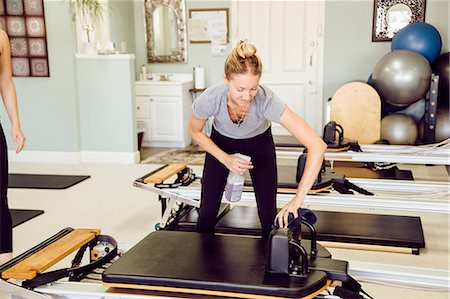 pilates reformer - Women in gym cleaning pilates reformer Stock Photo - Premium Royalty-Free, Code: 614-08826713