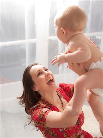 simsearch:640-06051822,k - Mother lifting baby daughter in air, laughing Photographie de stock - Premium Libres de Droits, Code: 614-08826800