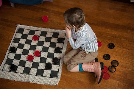 simsearch:632-08001843,k - Girl sitting on wooden floor playing draughts Photographie de stock - Premium Libres de Droits, Code: 614-08826848