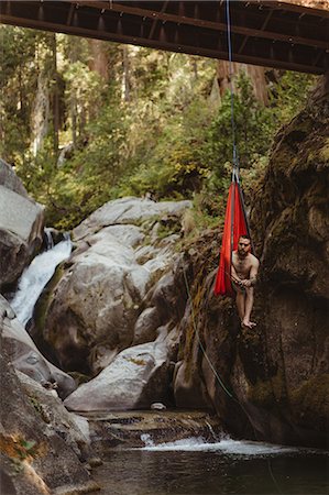 simsearch:614-08081221,k - Young man sitting in hammock, suspended from bridge,  holding fishing rod, Mineral King, Sequoia National Park, California, USA Stock Photo - Premium Royalty-Free, Code: 614-08826877