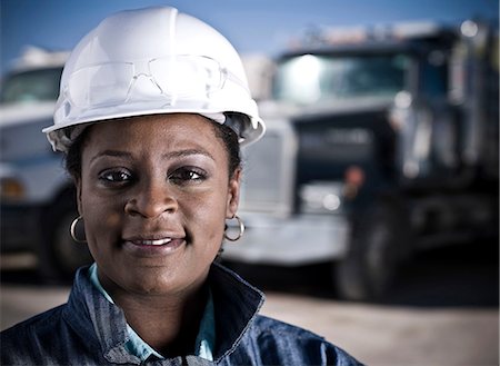 recycle center - Portrait of female worker in hard hat in front of recycling plant trucks Stock Photo - Premium Royalty-Free, Code: 614-08827032