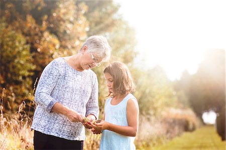 simsearch:614-08946674,k - Grandmother showing granddaughter the seeds inside of a milkweed pod Foto de stock - Sin royalties Premium, Código: 614-08827106