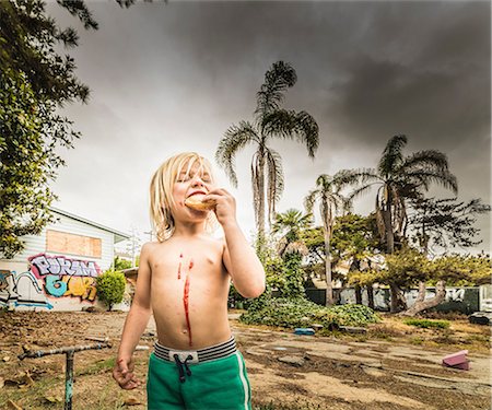 simsearch:632-03847652,k - Boy eating treat with jam dripping down chest Foto de stock - Sin royalties Premium, Código: 614-08827123