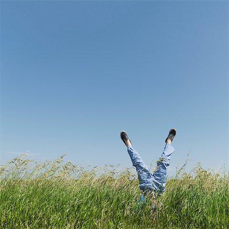 Boy doing handstand in tall grass Foto de stock - Sin royalties Premium, Código: 614-08827130