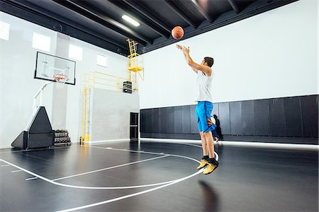 simsearch:614-08578805,k - Male basketball player jumping to throw ball in basketball hoop Photographie de stock - Premium Libres de Droits, Code: 614-08827230
