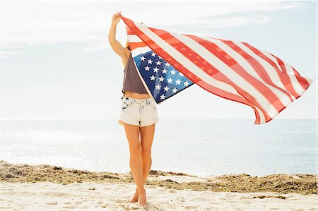 simsearch:614-08827383,k - Woman on beach arms raised holding american flag Photographie de stock - Premium Libres de Droits, Code: 614-08827386