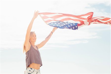 flag - Woman with arms raised holding american flag Stock Photo - Premium Royalty-Free, Code: 614-08827387