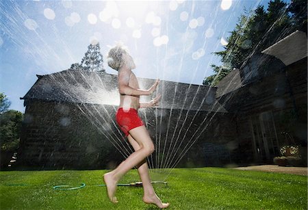 running sprinkler - Boy running through sprinklers Stock Photo - Premium Royalty-Free, Code: 614-08865496