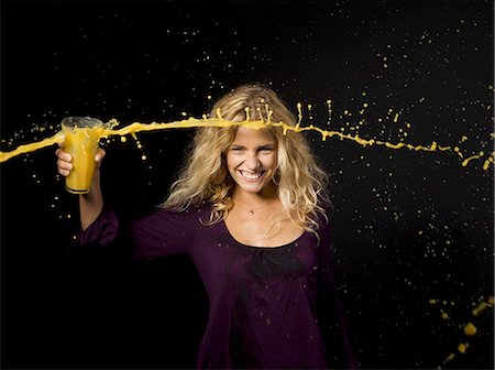 Woman throwing orange juice from a glass Fotografie stock - Premium Royalty-Free, Codice: 614-08865531