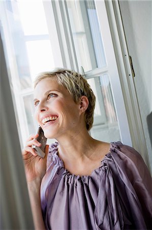 simsearch:649-05819775,k - Woman talking on cell phone by window Photographie de stock - Premium Libres de Droits, Code: 614-08865618