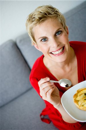 Woman in red dress eating pie Stock Photo - Premium Royalty-Free, Code: 614-08865627