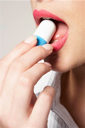 Woman with huge pill in mouth Stock Photo - Premium Royalty-Free, Code: 614-08865770