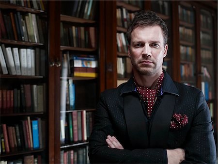 Man in suit standing in library Stock Photo - Premium Royalty-Free, Code: 614-08865815