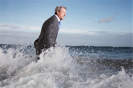 A businessman wading into the sea Stock Photo - Premium Royalty-Free, Code: 614-08865960