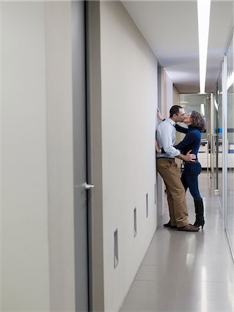 sexually excited man at office - Couple kissing in an office corridor Stock Photo - Premium Royalty-Free, Code: 614-08866040