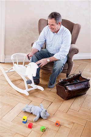 screwdriver (tool) - man sitting in chair repairing toys Stock Photo - Premium Royalty-Free, Code: 614-08866072