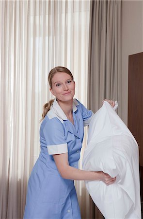 room maid fluffing up pillow, laughing Stock Photo - Premium Royalty-Free, Code: 614-08866166