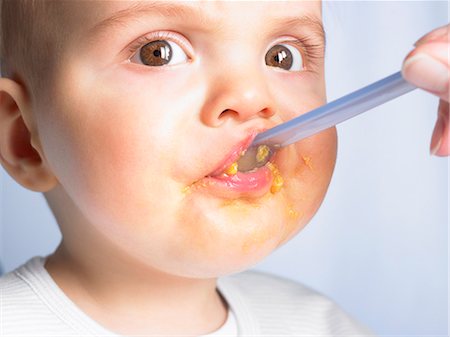 pictures of baby eating dinner with family - Portrait of a baby boy,eating Stock Photo - Premium Royalty-Free, Code: 614-08866372