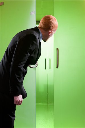 Man looking through green glass doors Stock Photo - Premium Royalty-Free, Code: 614-08866452
