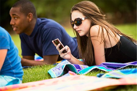 teen in grass text messaging on mobile Stock Photo - Premium Royalty-Free, Code: 614-08866618