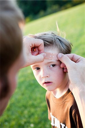 simsearch:614-03020295,k - Father Applying Bandage to Son's Head Fotografie stock - Premium Royalty-Free, Codice: 614-08866742