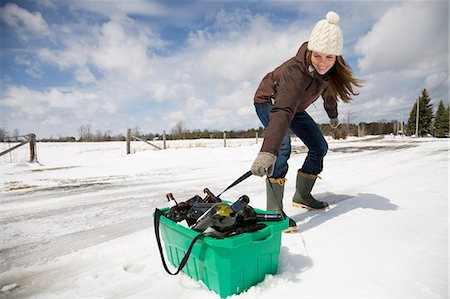 Woman dragging recycling in snow Stock Photo - Premium Royalty-Free, Code: 614-08866921