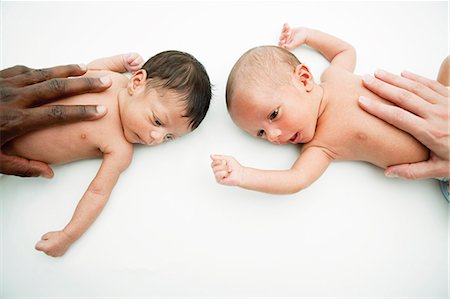 Multiracial hands on baby's stomachs Stock Photo - Premium Royalty-Free, Code: 614-08866933