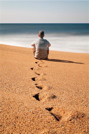 simsearch:614-06624161,k - Man sitting on beach, looking out to sea Photographie de stock - Premium Libres de Droits, Code: 614-08867199