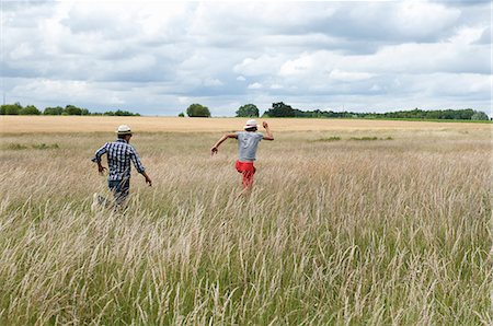 simsearch:614-08868276,k - Men running in wheat field Photographie de stock - Premium Libres de Droits, Code: 614-08867768