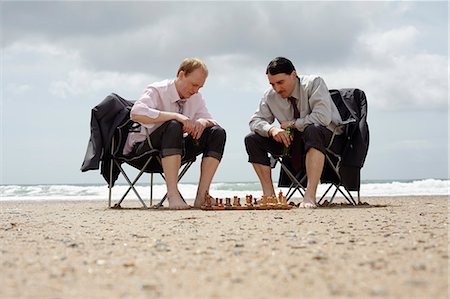 Businessmen playing chess on beach Stock Photo - Premium Royalty-Free, Code: 614-08867832