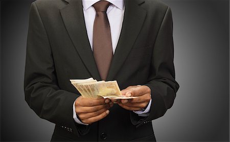 Businessman counting euros Stock Photo - Premium Royalty-Free, Code: 614-08867844