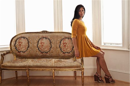 fashion lounge - Woman sitting on arm of sofa Stock Photo - Premium Royalty-Free, Code: 614-08868116