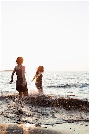 Women playing in waves on beach Stock Photo - Premium Royalty-Free, Code: 614-08868149