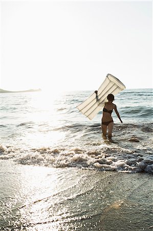 Woman with inflatable mattress on beach Photographie de stock - Premium Libres de Droits, Code: 614-08868158