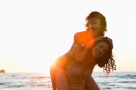 friend playing piggyback - Women playing together on beach Stock Photo - Premium Royalty-Free, Code: 614-08868168