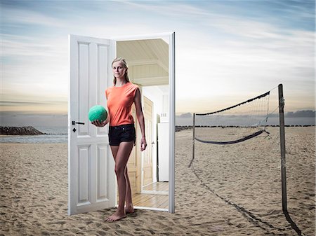 Woman emerging from door on beach Stock Photo - Premium Royalty-Free, Code: 614-08868253