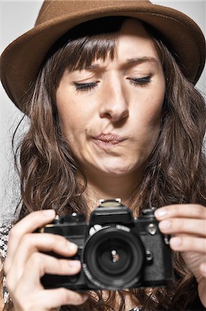 Confused woman examining camera Photographie de stock - Premium Libres de Droits, Code: 614-08868294